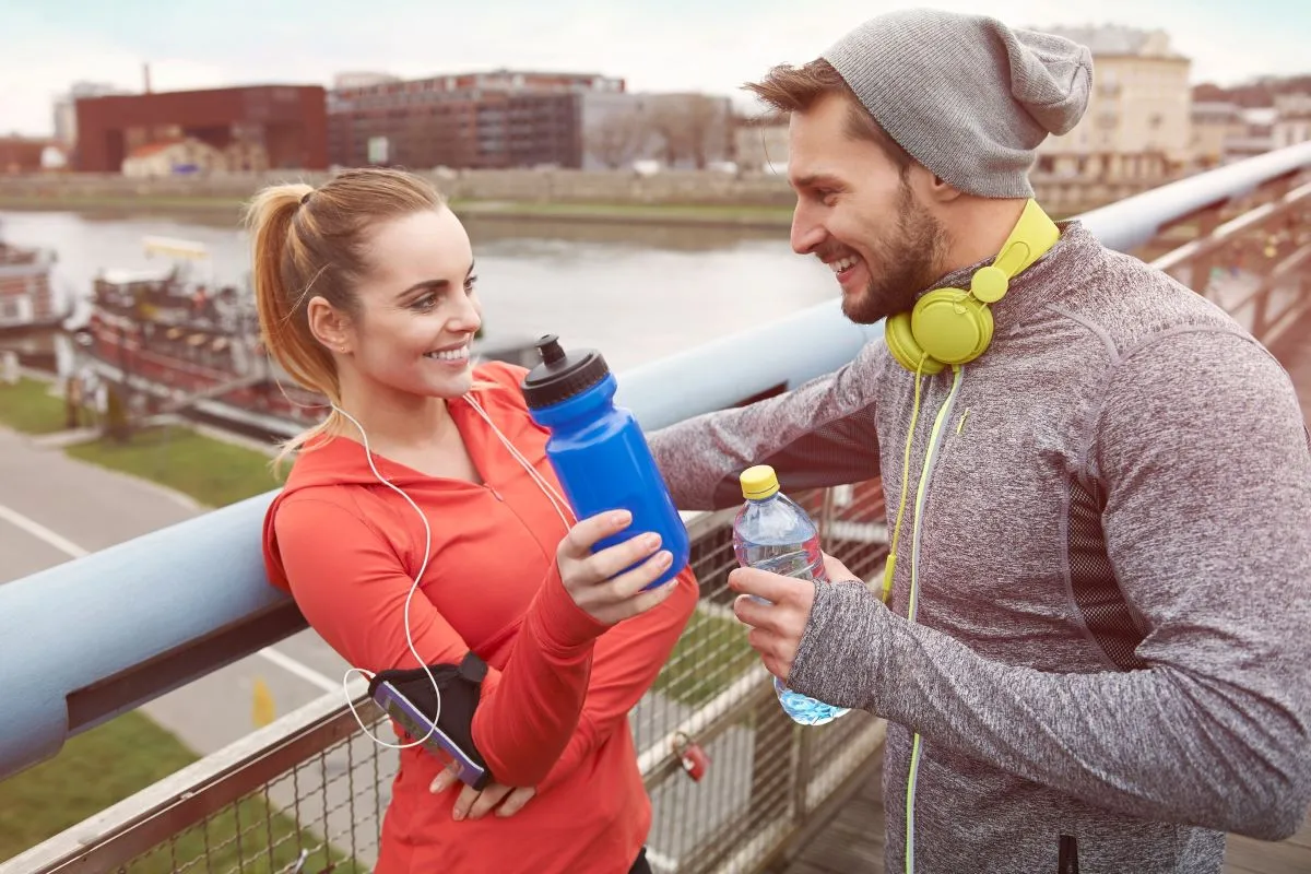 Happy couple drinking water after exercise